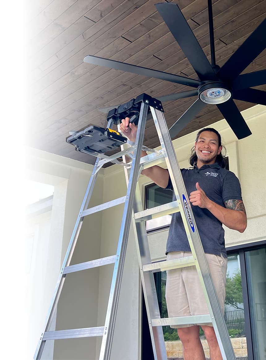 Mark performing house repairs on a ladder, wearing a grey polo with the Best Texas House Buyers LLC logo, showcasing hands-on real estate investment expertise.