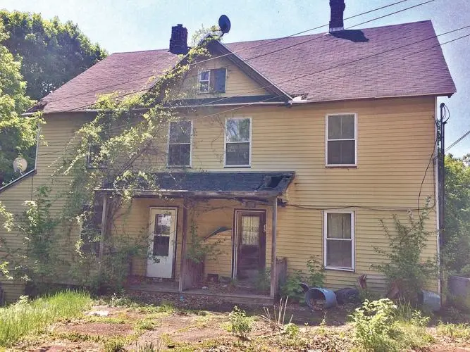 Vacant and neglected yellow house with overgrown plants, representing a distressed property that Best Texas House Buyers can purchase for cash in Dallas